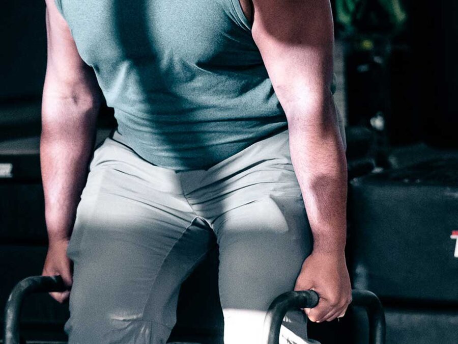 An adult athlete gripping loaded handles