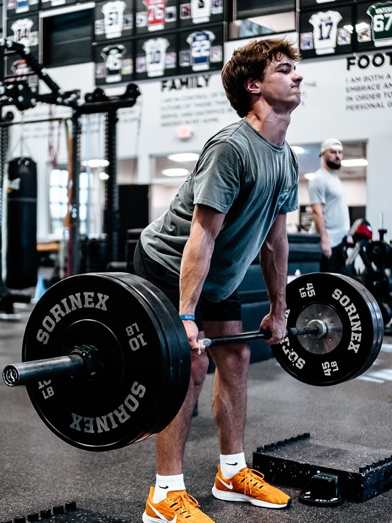 An athlete setting up for a barbell lift during an LTAD session